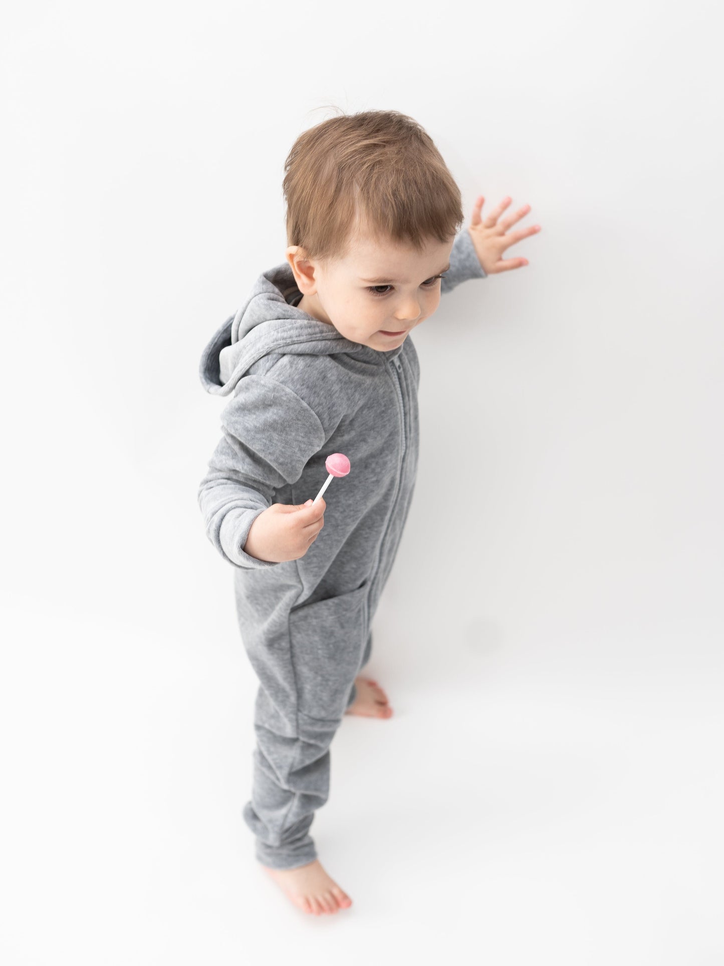 Pilko melanžo spalvos vaikiškas kombinezonas su gobtuvu ir kišenėmis